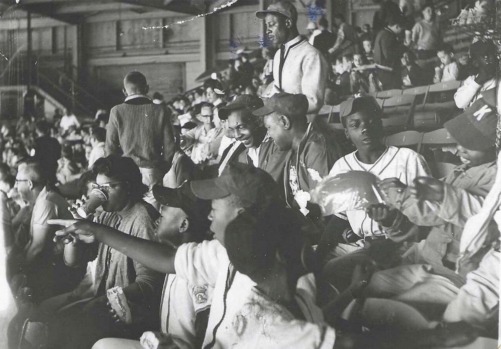 Ernest Webster with young people at a community baseball game